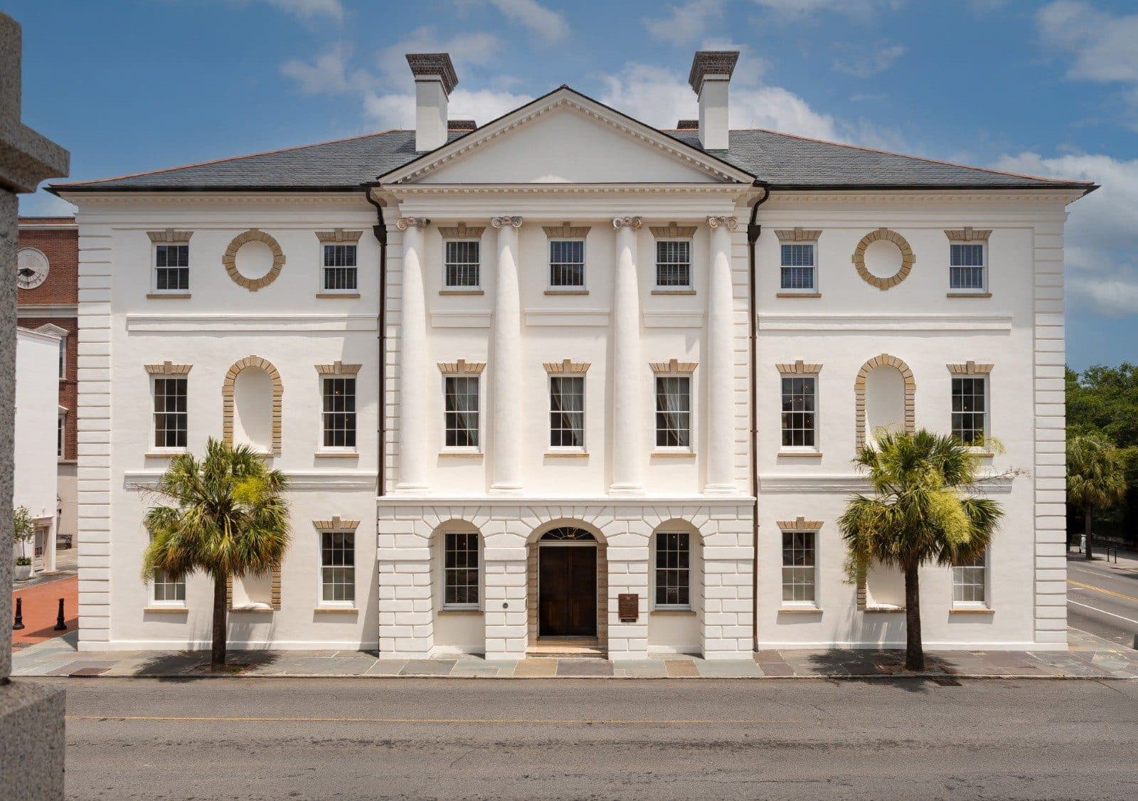 Historic Charleston public building with palmettos under a clear sky