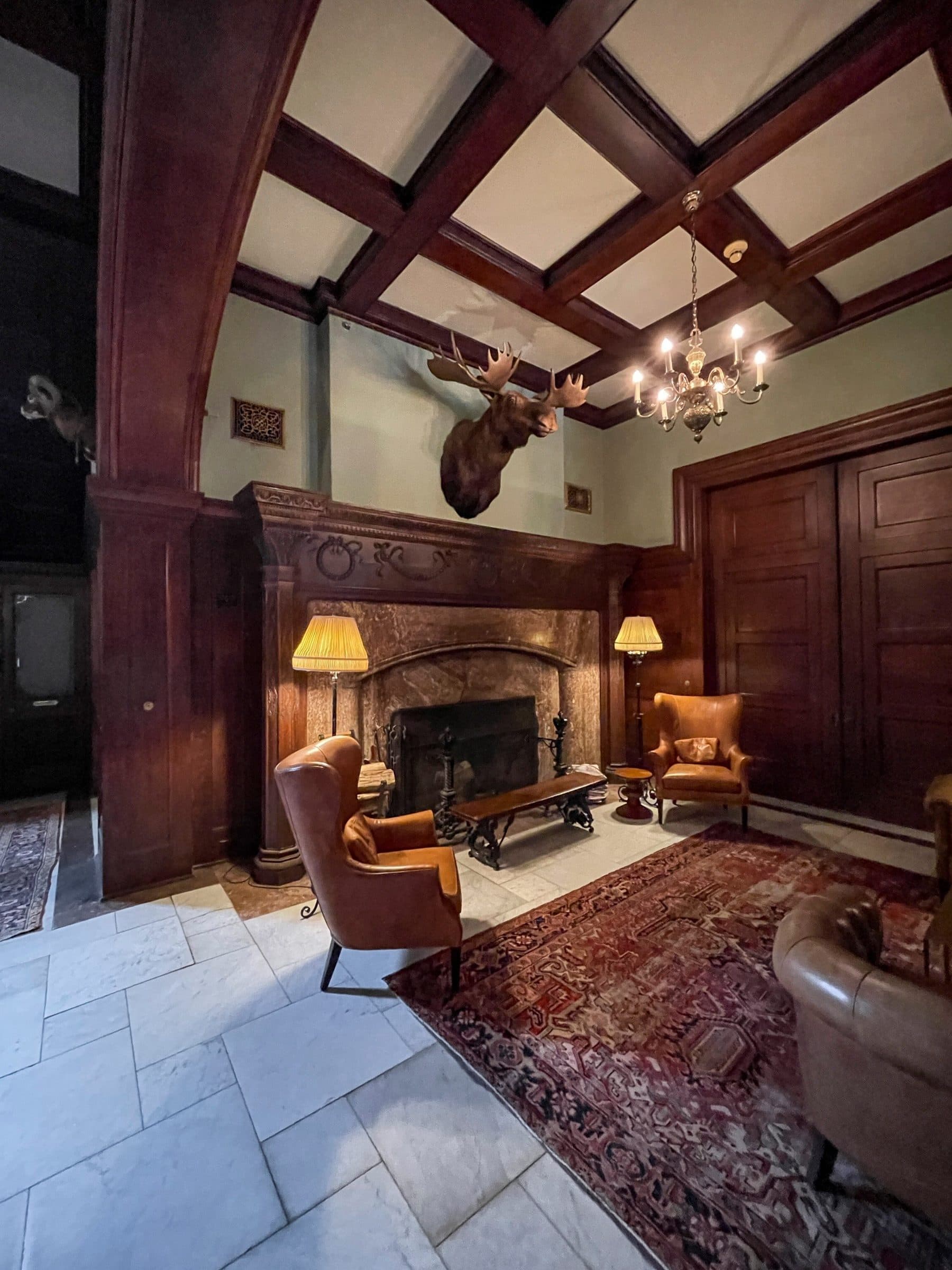 Paneled lounge with coffered ceiling and fireplace
