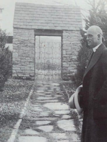Historic photograph of a parishioner at the stone gate