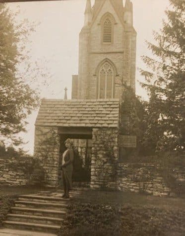 Historic photograph of the church entrance with figure
